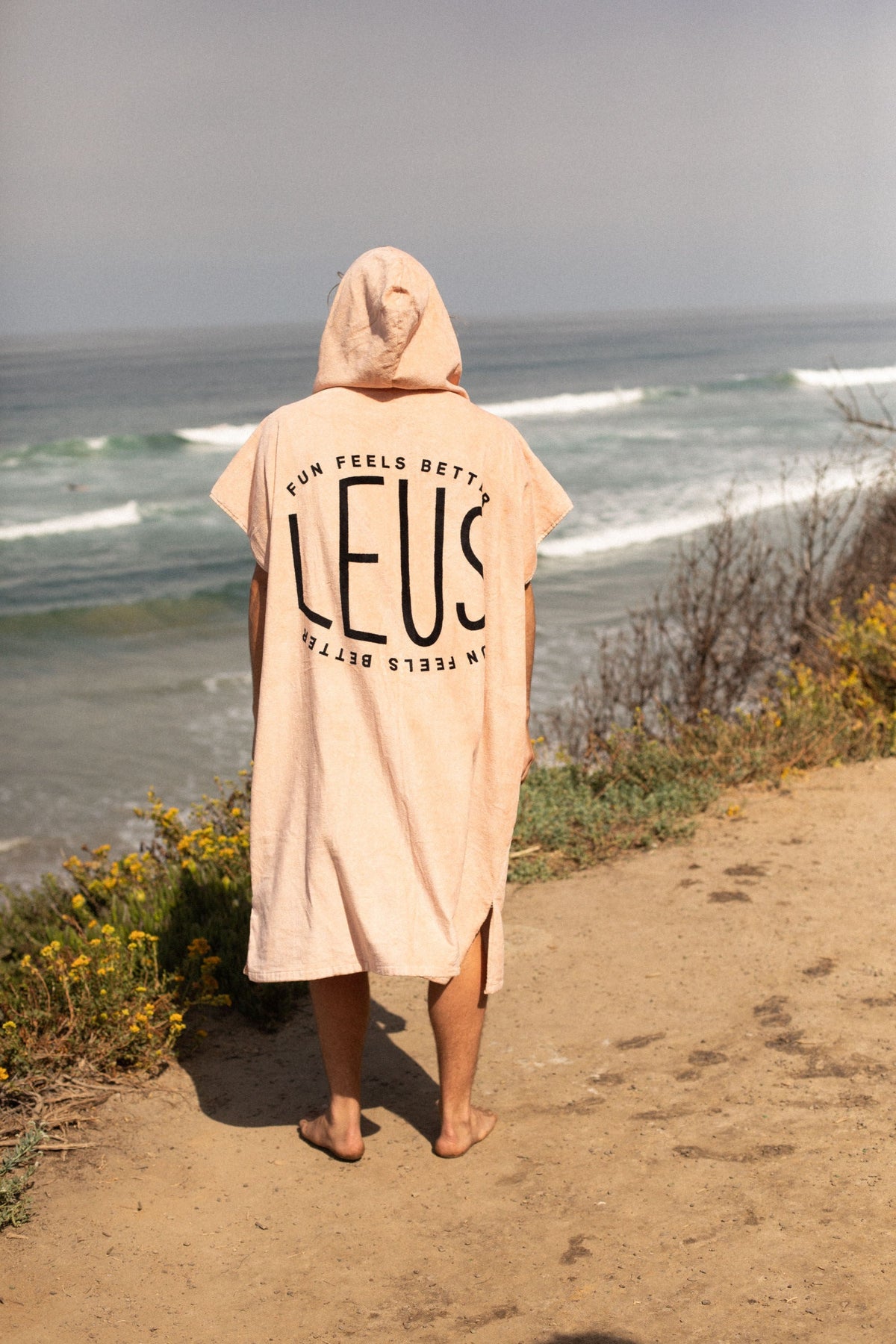 Happy Hour Original Eco Poncho: full length from behind on the cliff path - Leus Towels Australia