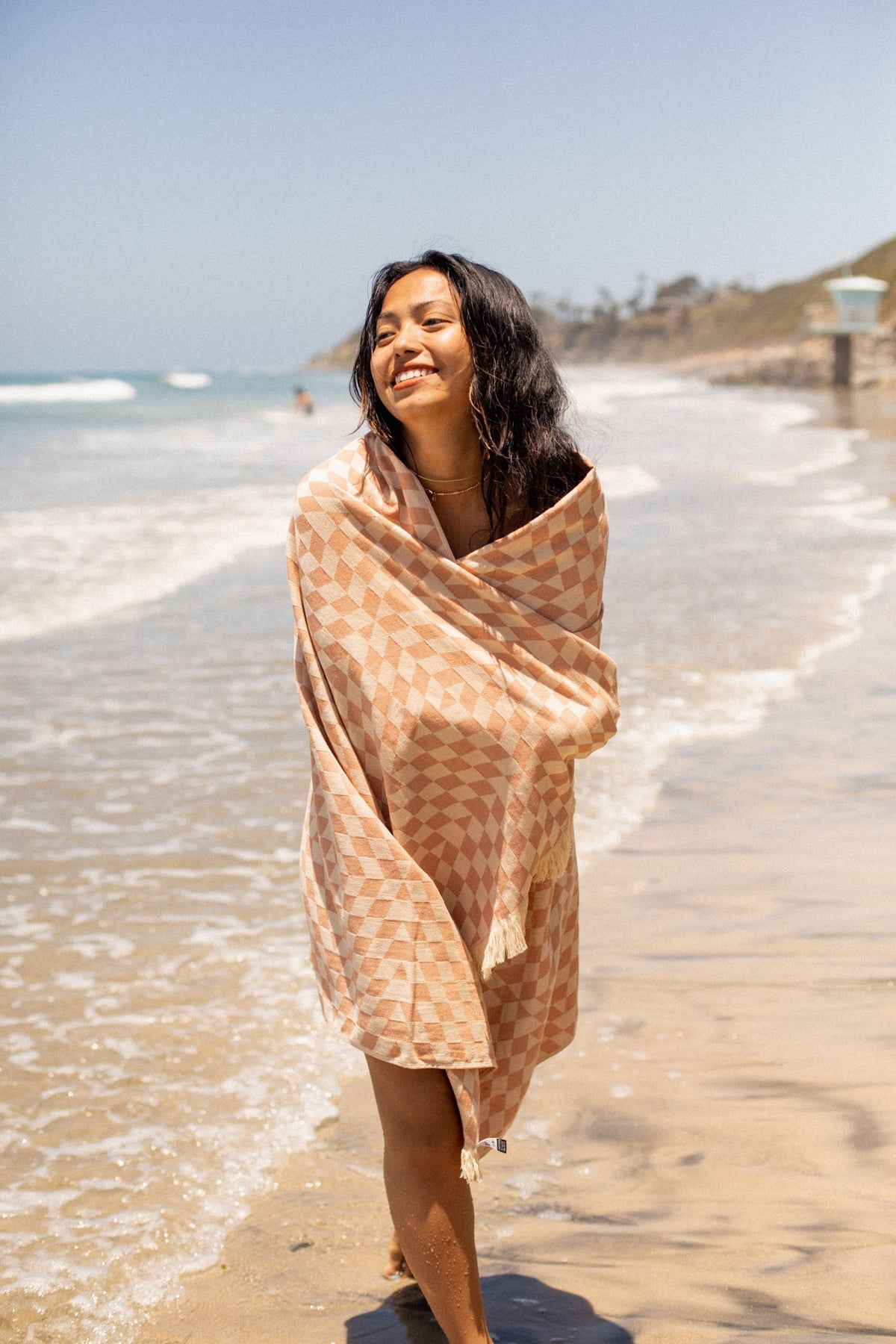 Terracotta Turkish Eco Towel: woman wrapped, walking at the beach - Leus Towels Australia